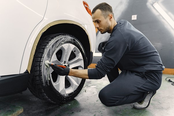 Man cleaning alloy wheel