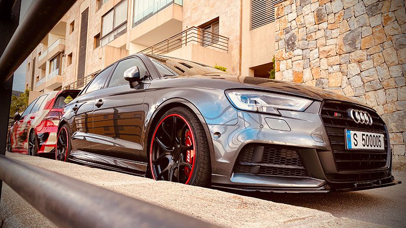 Audi with red AlloyGator wheel protection parked against a curb