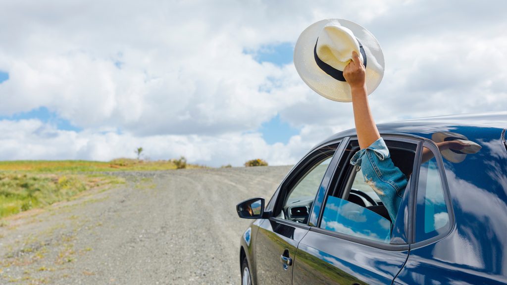 Car on a scenic summer road trip, showcasing well-maintained features with AlloyGator and Rimblades.